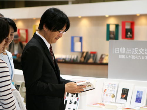 한국 테마관에서 박경리 소설 토지의 일본어판을 펼쳐보는 아키시노미야 왕자