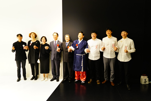 포토그래퍼의 사인에 웃으면서 사진을 찍고 있는 참여 작가와 해외문화홍보원장, 주일한국문화원장, 일본문화청장관